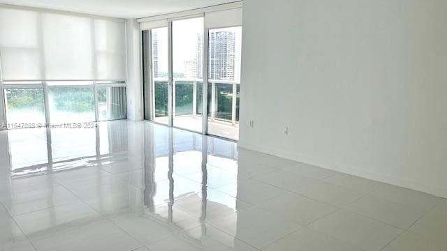 spare room with floor to ceiling windows and light tile patterned floors