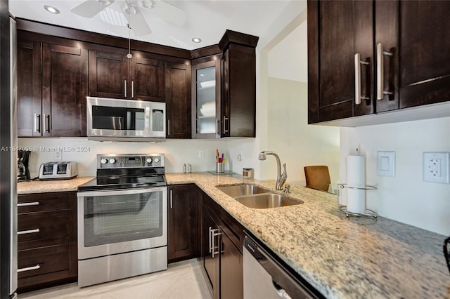 kitchen featuring ceiling fan, light stone countertops, light tile patterned floors, sink, and stainless steel appliances