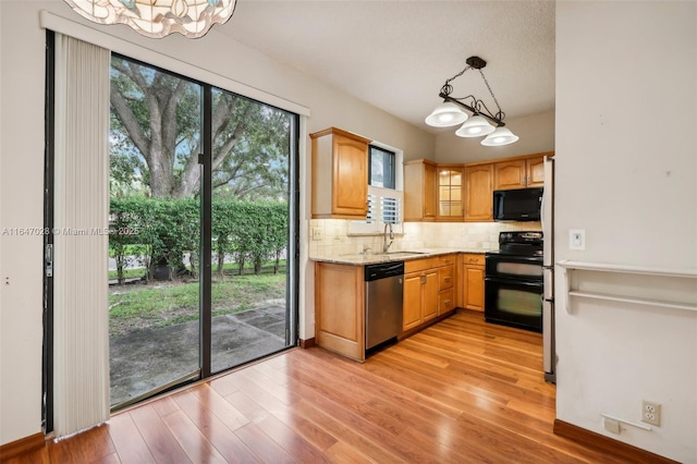 1010 NW 105th Way Unit B-139, Plantation, FL 33322 - kitchen featuring black appliances, a sink, backsplash, a chandelier, and light wood-style floors