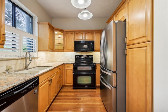 1010 NW 105th Way Unit B-139, Plantation, FL 33322 - kitchen with black appliances, a sink, light wood-style floors, light stone counters, and decorative backsplash