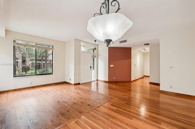 spare room with a textured ceiling and hardwood / wood-style flooring