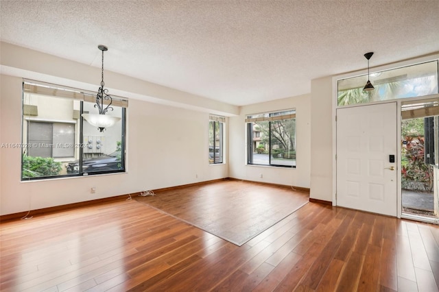 foyer entrance with dark wood-type flooring and a textured ceiling