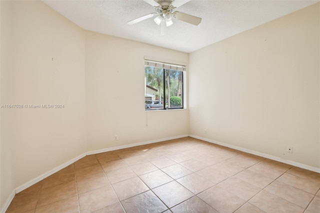 tiled empty room featuring a textured ceiling and ceiling fan