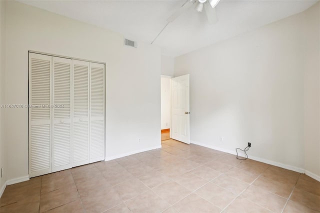 unfurnished bedroom featuring ceiling fan, a closet, and light tile patterned floors