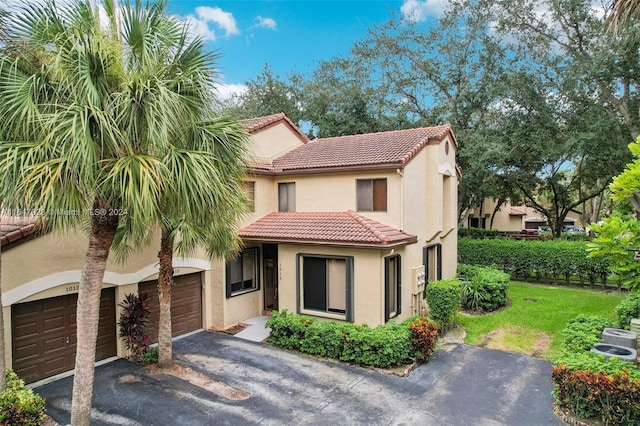 mediterranean / spanish house with a front yard and a garage