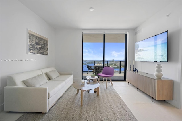 living room with a wall of windows and light tile patterned floors