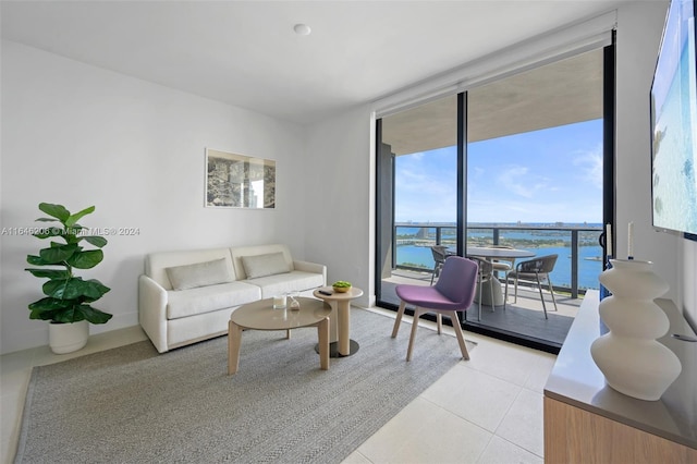 living room featuring light tile patterned flooring, a wall of windows, and a water view