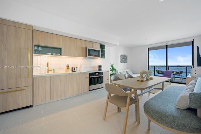 tiled dining space with sink and a wall of windows