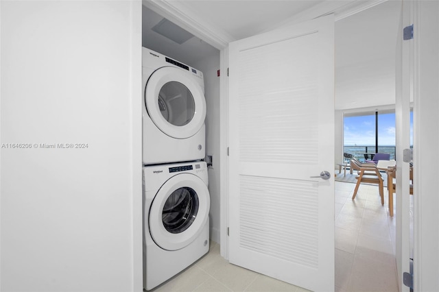 washroom featuring light tile patterned floors and stacked washer / dryer