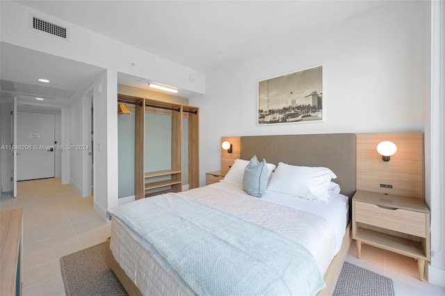 tiled bedroom featuring a closet and a barn door