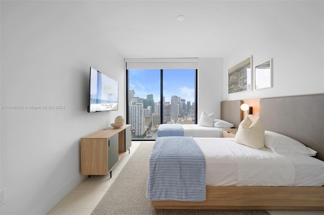 bedroom with floor to ceiling windows and light tile patterned floors