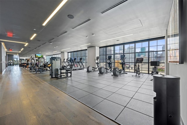 exercise room with light hardwood / wood-style flooring and a wall of windows