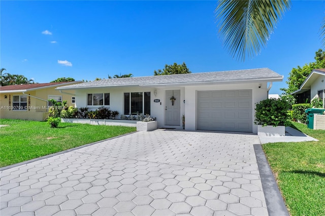 ranch-style house with a garage and a front lawn