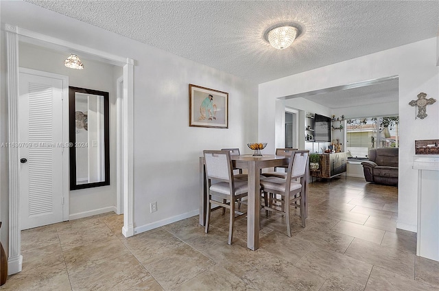 tiled dining room with a textured ceiling