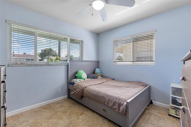 tiled bedroom with a textured ceiling and ceiling fan