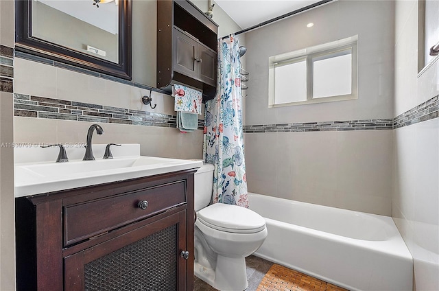 full bathroom with shower / bath combination with curtain, toilet, vanity, and tile walls