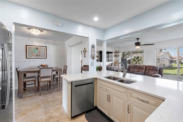 kitchen featuring ceiling fan, dishwasher, cream cabinets, light tile patterned floors, and sink