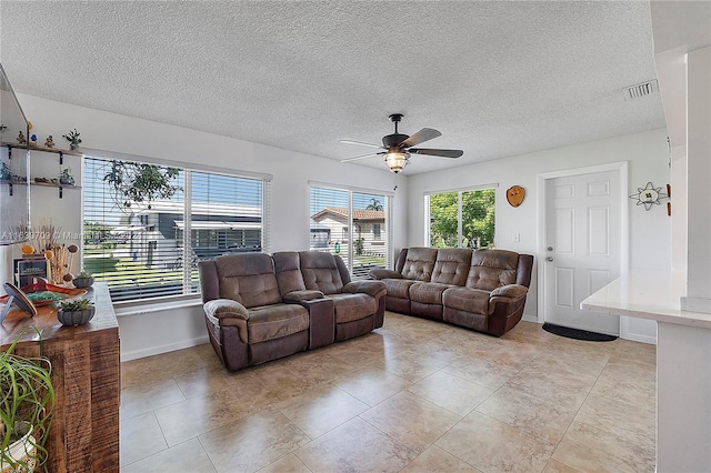 tiled living room featuring ceiling fan and a textured ceiling