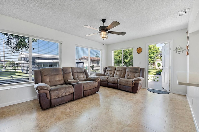 tiled living room with a textured ceiling and ceiling fan