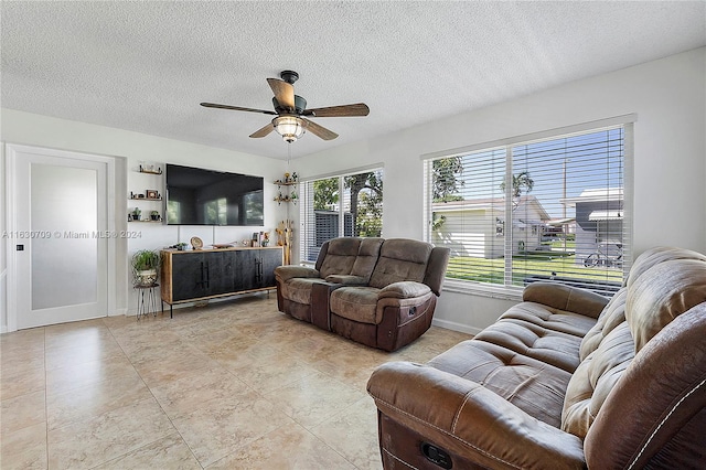 tiled living room featuring ceiling fan and a textured ceiling