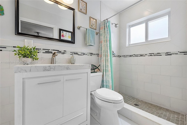 bathroom featuring tile walls, curtained shower, vanity, and toilet