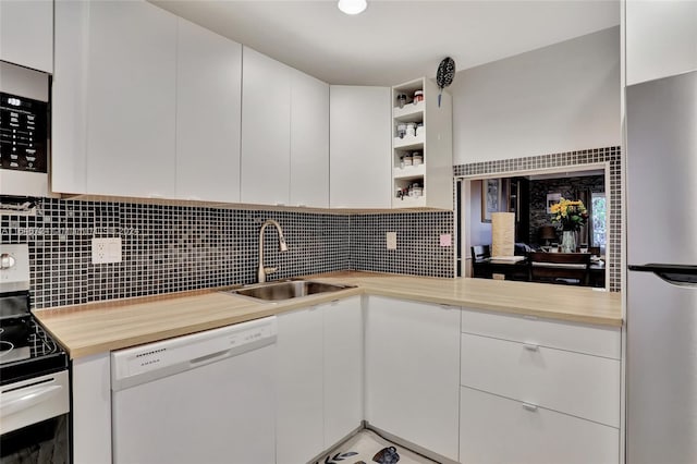 kitchen featuring sink, backsplash, white cabinetry, and stainless steel appliances