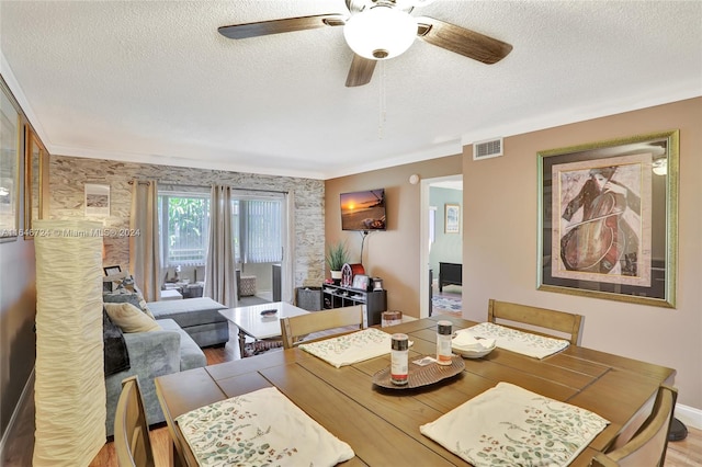 dining room featuring ceiling fan, hardwood / wood-style floors, and a textured ceiling