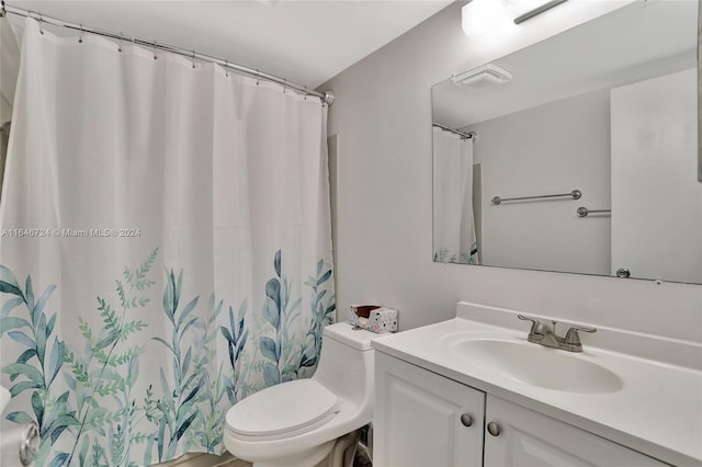 bathroom with toilet, vanity, and a shower with curtain