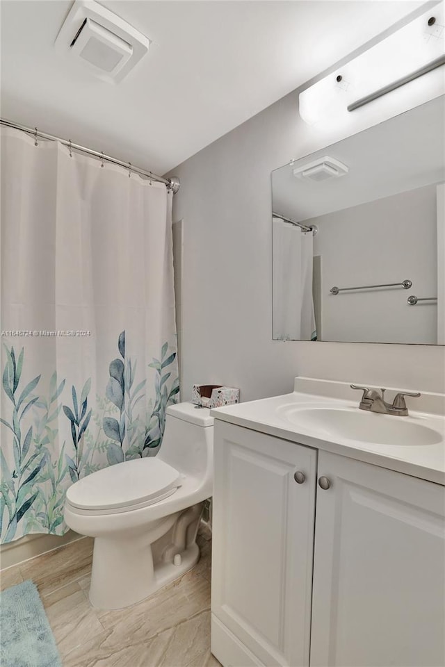 bathroom with toilet, vanity, and a shower with curtain