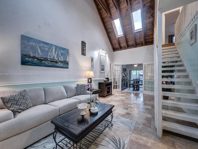 living room featuring wood ceiling, a skylight, and a high ceiling