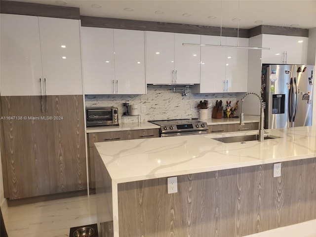 4741 NE 19th Ave, Fort Lauderdale, FL 33308 - kitchen with stainless steel appliances, white cabinets, a sink, and light stone countertops