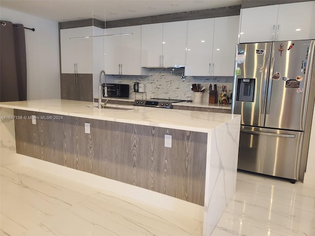 4741 NE 19th Ave, Fort Lauderdale, FL 33308 - kitchen with light stone countertops, white cabinetry, modern cabinets, and appliances with stainless steel finishes