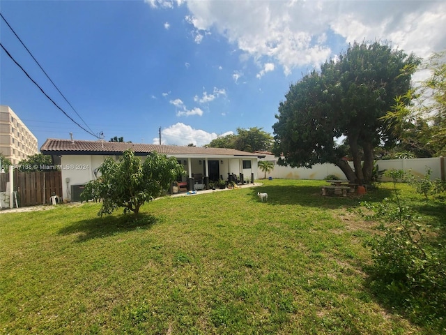 4741 NE 19th Ave, Fort Lauderdale, FL 33308 - back of property with a tile roof, a patio area, a fenced backyard, and a lawn