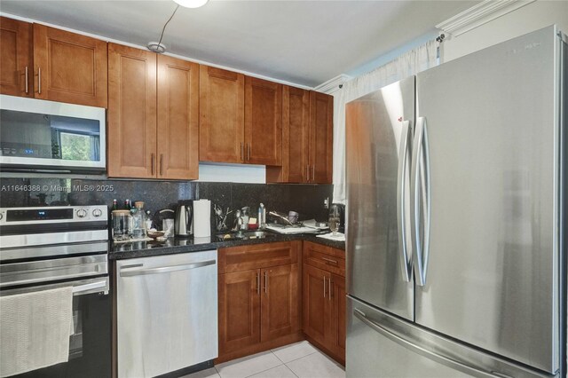 kitchen with light tile patterned floors, appliances with stainless steel finishes, decorative backsplash, and a breakfast bar