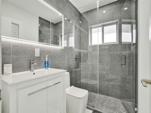 bathroom featuring tile walls, backsplash, toilet, a stall shower, and vanity