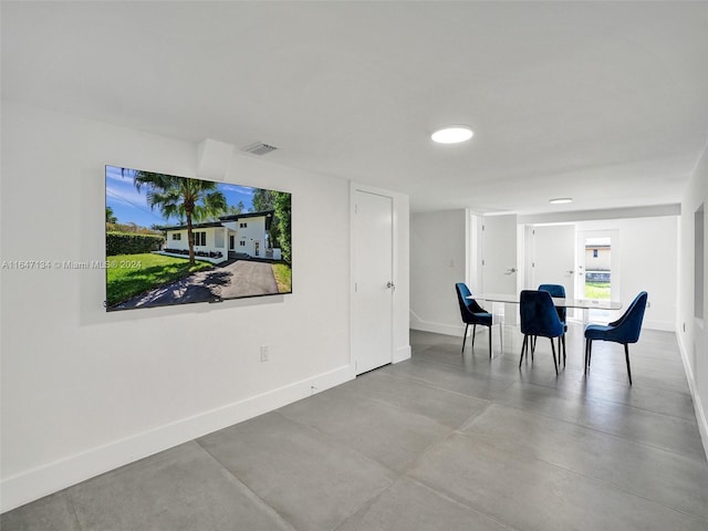 dining room with visible vents, concrete floors, and baseboards