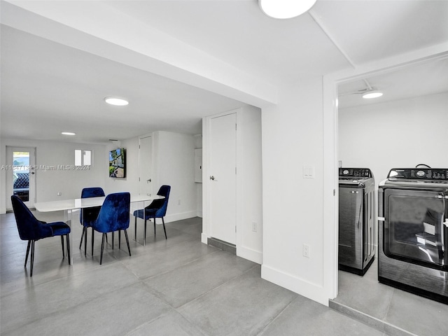 dining area featuring finished concrete floors, baseboards, and washing machine and clothes dryer