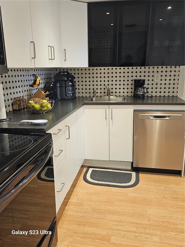 kitchen featuring white cabinets, backsplash, stainless steel appliances, and light hardwood / wood-style flooring