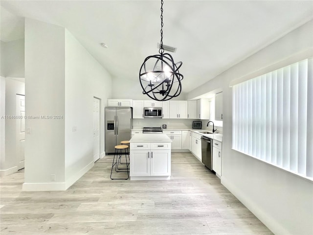 kitchen featuring sink, a kitchen island, appliances with stainless steel finishes, light hardwood / wood-style floors, and white cabinetry