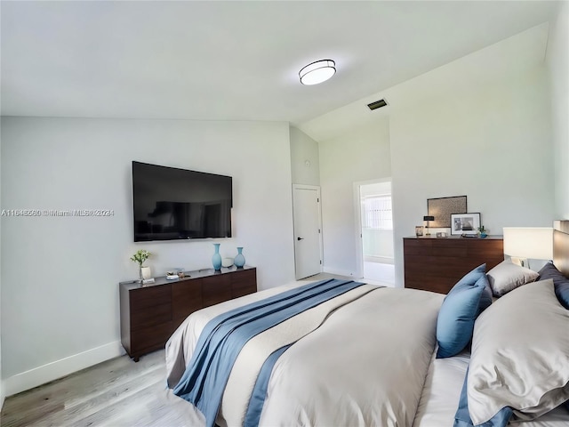 bedroom with light hardwood / wood-style floors and vaulted ceiling