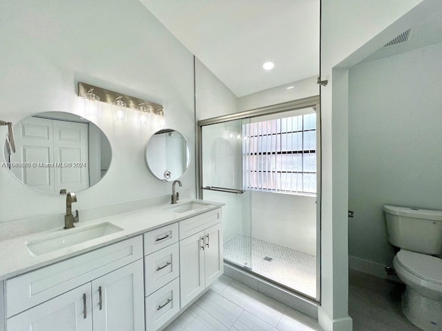 bathroom featuring tile patterned floors, vanity, a shower with shower door, and toilet