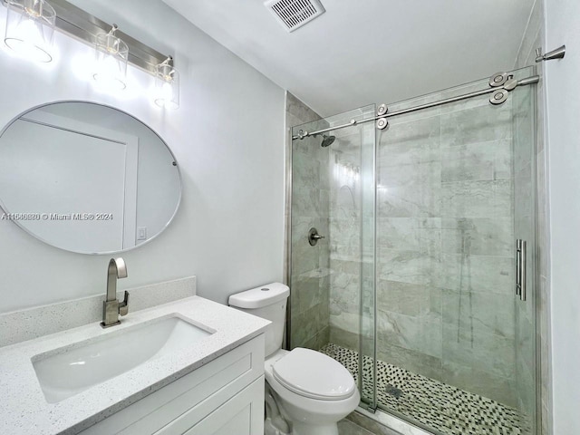 bathroom with vanity, toilet, and a shower with shower door