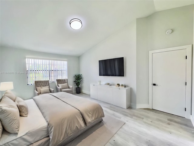 bedroom featuring light hardwood / wood-style floors and lofted ceiling