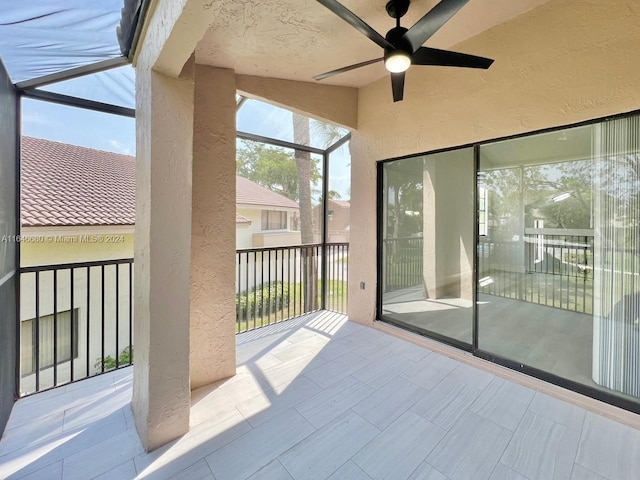 unfurnished sunroom with ceiling fan