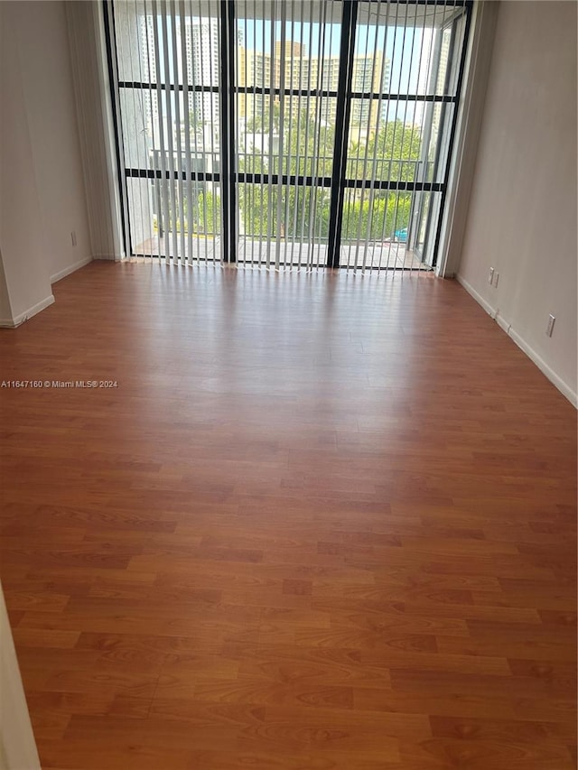 spare room with wood-type flooring and plenty of natural light