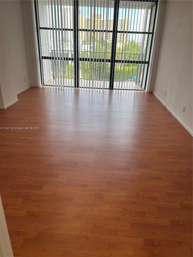 empty room with wood finished floors and baseboards