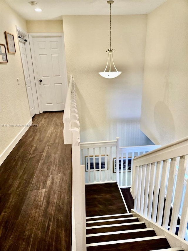 stairway with hardwood / wood-style flooring and a textured ceiling