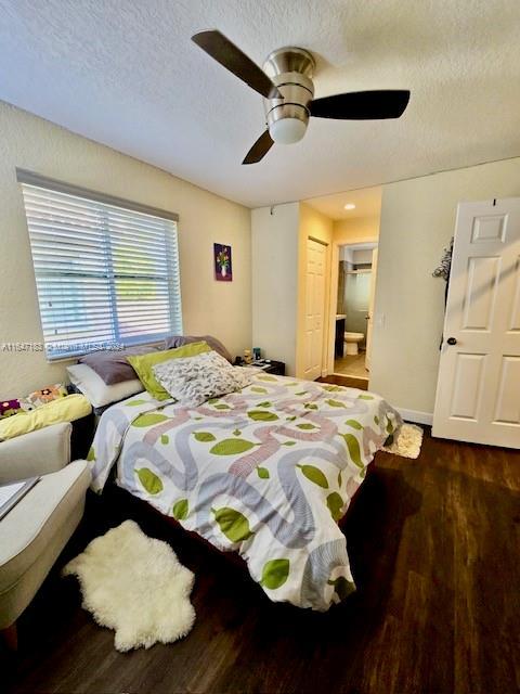 bedroom with dark hardwood / wood-style flooring, a textured ceiling, a closet, and ceiling fan