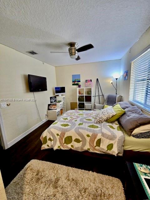 bedroom featuring ceiling fan, a textured ceiling, and hardwood / wood-style floors