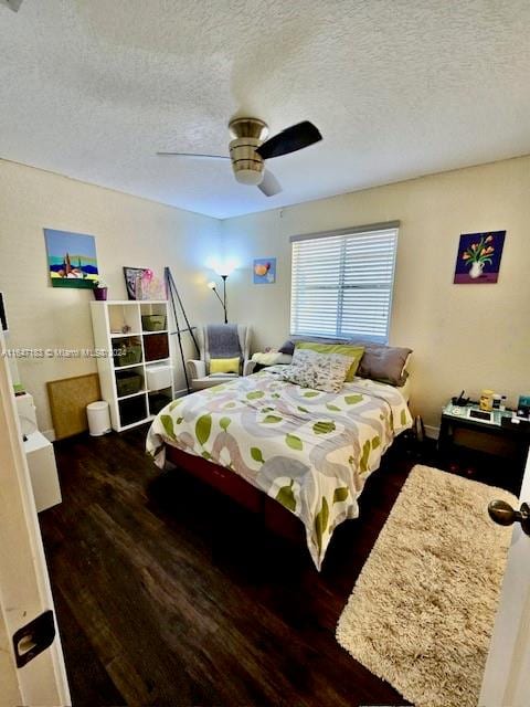 bedroom with a textured ceiling, dark hardwood / wood-style floors, and ceiling fan